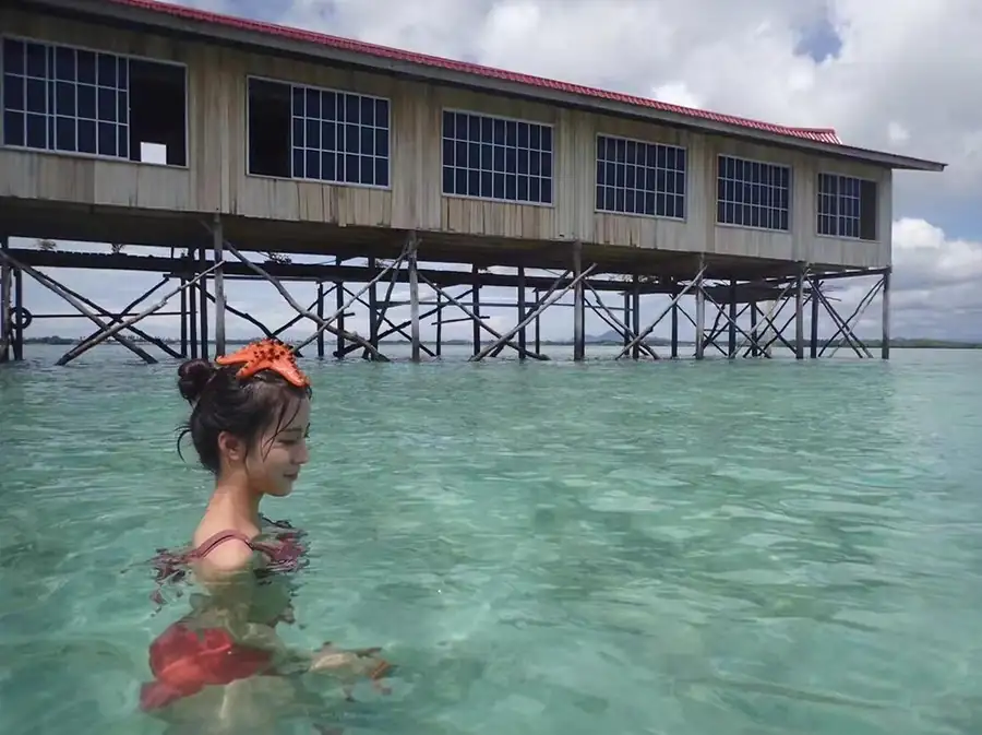 Guests swimming in the crystal clear turquoise sea Grand Dive Resort